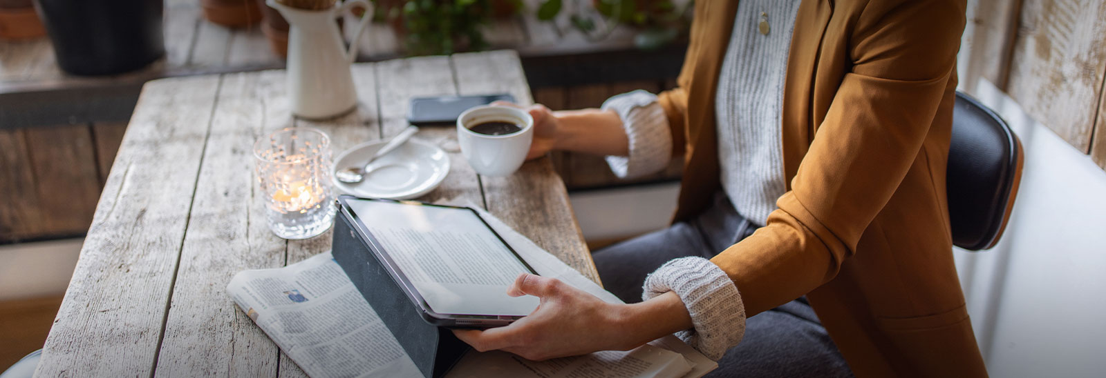 Mujer leyendo noticias con café en mano